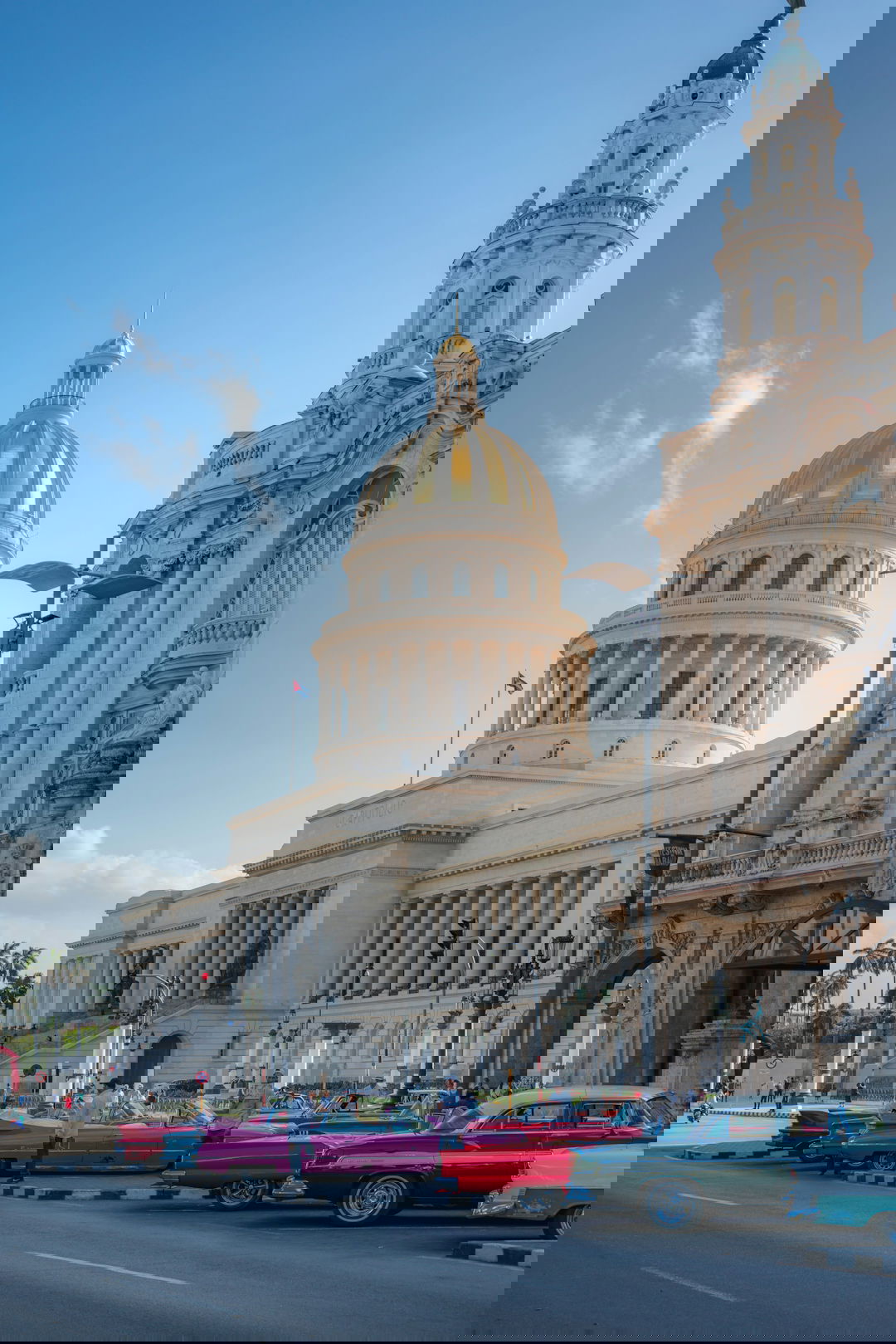 people walking on sidewalk near white concrete building during daytime